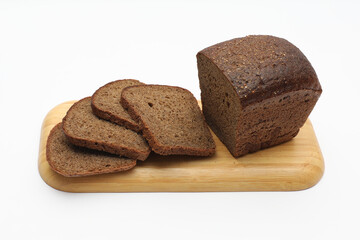 Rye bread on wooden cutting board on a white background
