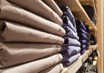 Neat stacks of folded clothing on the shop shelves