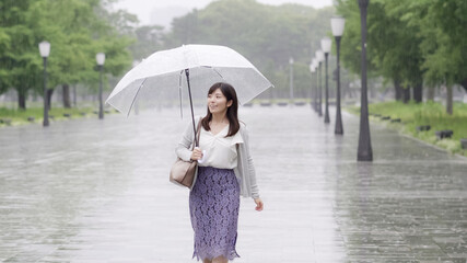 雨の日に通勤するビジネスウーマン　手持ち撮影