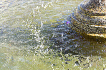 Gotas de agua en detalle de una fuente ornamental en un parque público en un día soleado de...