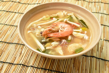 boiled shrimp and chicken with mussel in Thai spicy tom yum soup on bowl