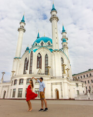 Young couple dancing in front of mosque in Kazan, Russia. Red dress.