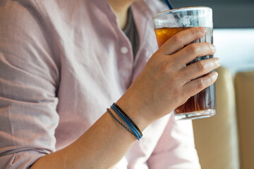 Man Sitting with Iced Coffee Cup in Hand.