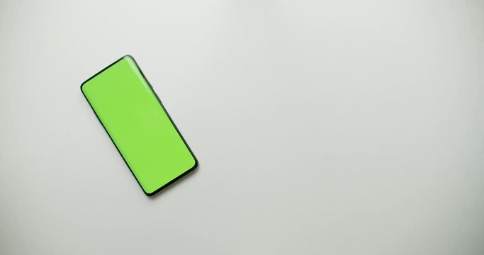 Money and calculator moves avay, then smartphone with green scren appeares, chromakey. Place for advertising. Mobile banking instead of paper currency and old calculator. Commercial packshot concept