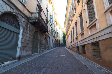 Naklejka na ściany i meble Medieval street in old Bergamo, diminishing perspective, low angle view