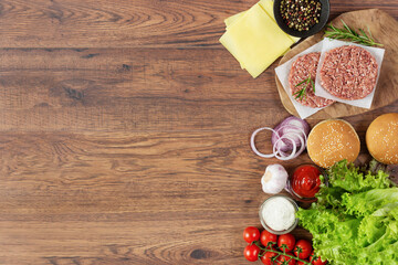 Fresh raw ingredients for homemade burger on wooden background.
