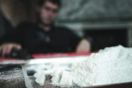 Big mountain of cocaine closeup. a man in a black shirt on a background of cocaine. dragdiller with gun on cocaine background. mafia boss cocaine addict