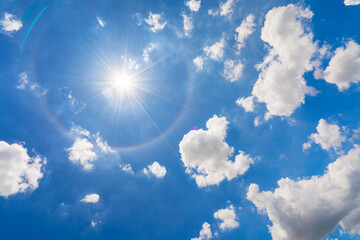 Vivid blue sky with white cloud and sun halo 
