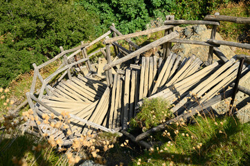 old homemade wooden staircase that runs over rocks in a mountain gorge