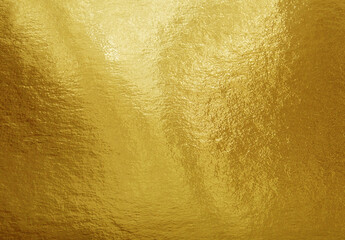 Gold foil texture background with highlights and uneven surface