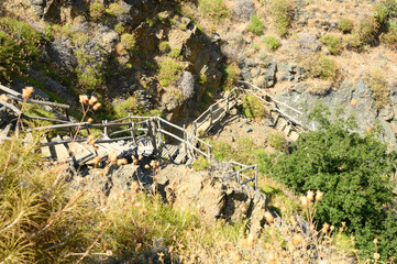 old homemade wooden staircase that runs over rocks in a mountain gorge