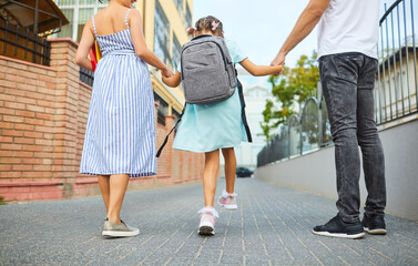 Family and schoolgirl with a backpack way to school