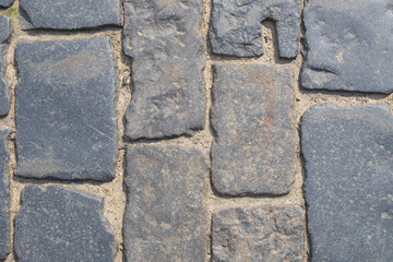 Fragment of a old cobblestone pavement. Horizontal orientation, selective focus.