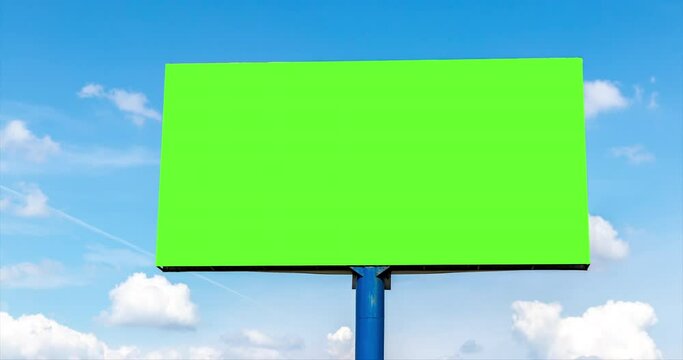 advertising billboard outdoor with green blank screen against beautiful blue sky time lapse with cumulus clouds at summer. empty display with copy space and chroma key. natural landscape background