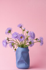 bright purple chamomile wildflowers on a pink background. summer spring simple bouquet. vertical photo