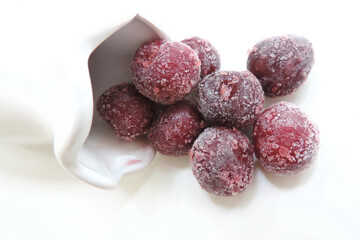   frozen ripe cherries covered with hoarfrost white background, selective focus      