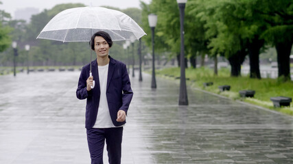 雨の日に傘を差して出かける男性　手持ち撮影