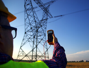 Engineer with gauge during power line infrastructure inspection