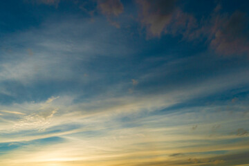 Naklejka na ściany i meble Blurred of blue sky with gold light and white clouds around.