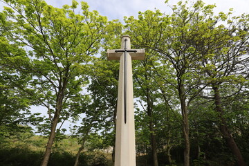 Christian memorial monument against a green background of trees.