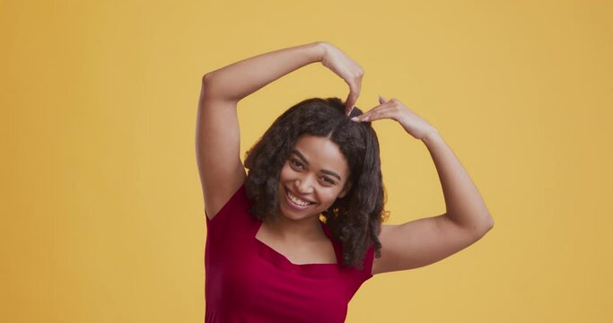 Happy black girl pretending to be big loving heart