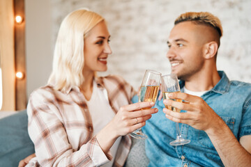 Young couple toasting wine glasses at home