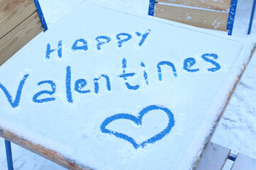happy valentine day and heard painting on table cover snow outside in winter