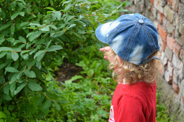 Caucasian child in denim cap outdoor in nature in summer lifestyle