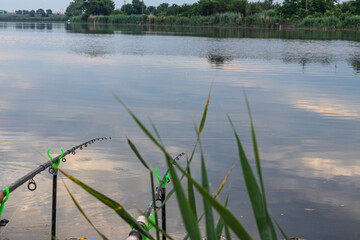fishing rod with a reel on the river bank. Sunrise. Early morning. Wild nature. The concept of rural recreation.