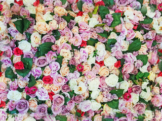Colorful artificial roses as a seamless background