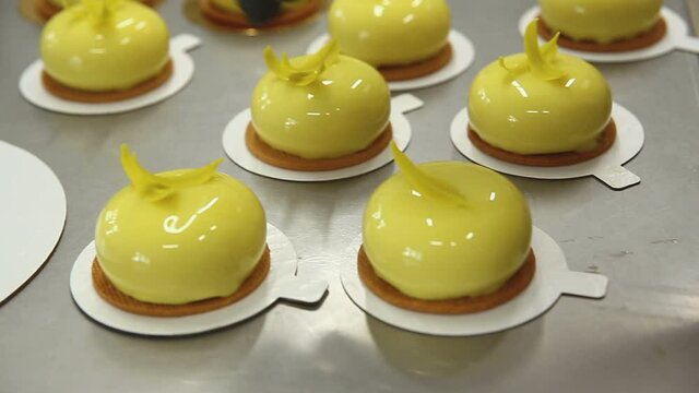 The pastry chef in the kitchen glazes pastries. Cook decorates glazed pastries with a decorative element. The process of cooking. Step by step. Tutorial.