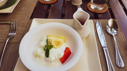 Yogurt with banana and watermelon on a white plate.