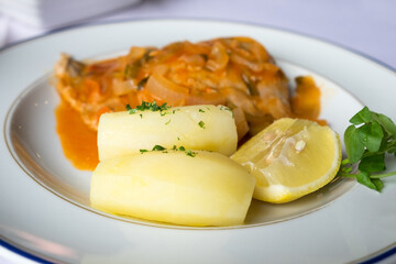 Traditional  seafood dish from Madeira cuisine - stewed scabbardfish in red vegetable sauce served with boiled potatoes