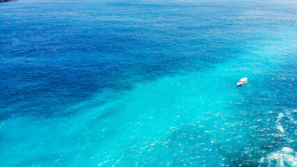 The sea water shimmers from dark blue to turquoise.