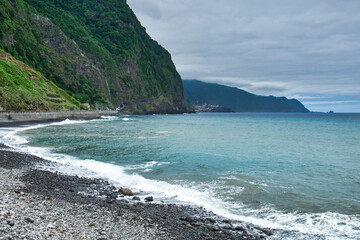 An ocean tide on the pebble beach of Madeira island