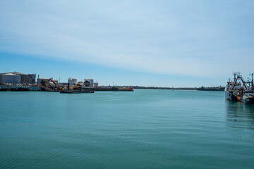 People min their daily life around the city center of Auckland (New Zealand), next to the ocean in a summer day, on the main streets. The city is full of shops and skyscrapers. Is a modern cityscape. 