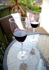 Two glasses with red wine on the table outside
