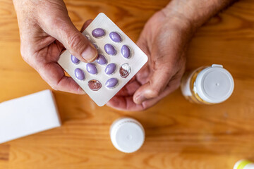 Senior man taking prescription medicine at home
