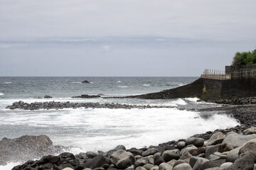 Fototapeta na wymiar An ocean tide on the pebble beach of Madeira island