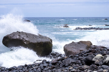 An ocean tide on the pebble beach of Madeira island