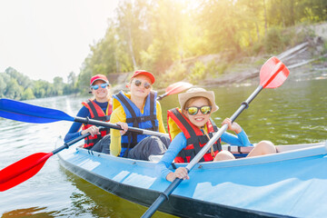 Happy boy kayaking on the river on a sunny day during summer vacation - 361336887