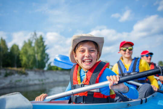 Happy boy kayaking on the river on a sunny day during summer vacation