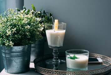 Creamy dessert in a glass on a tray with plant decoration and a mobile