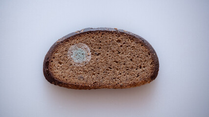 Moldy bread on a cutting board.