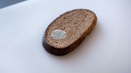 Moldy bread on a cutting board.