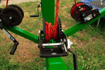 Green mechanism with metal skein of rope and orange twine in the park in nasty day