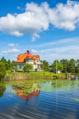 Lake with reflections and a beautiful house at the beach