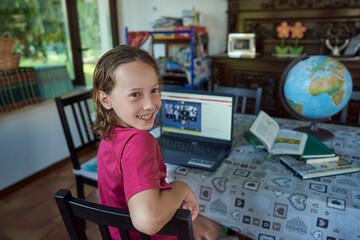 Girl smiling infront of the laptop at her home