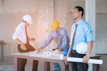 Portrait of handsome engineer with construction site background.