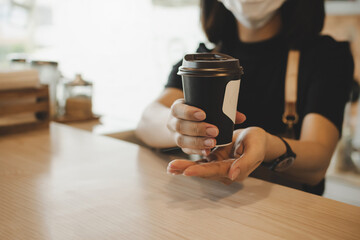 friendly woman barista wearing protection face mask waiting for serving hot coffee cup to customer in cafe coffee shop, cafe restaurant, service mind, small business owner, food and drink concept